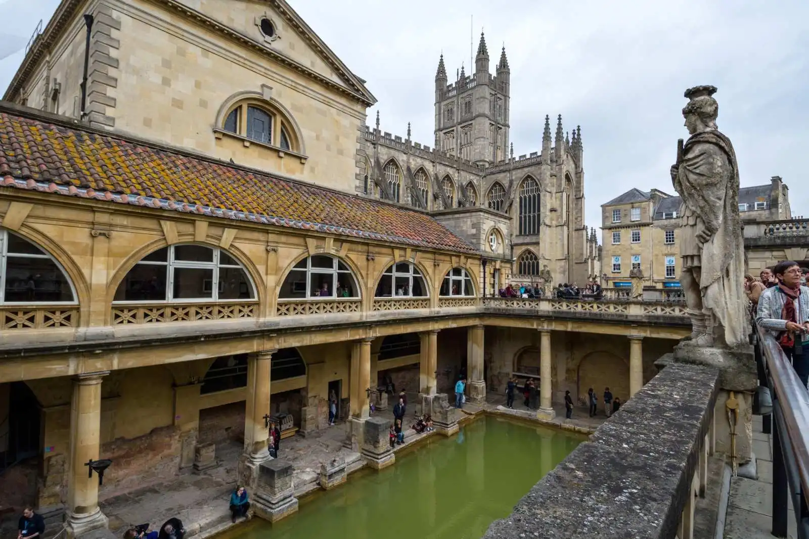 Great Bath s terasou a sochami římských císařů, v pozadí věž Bath Abbey